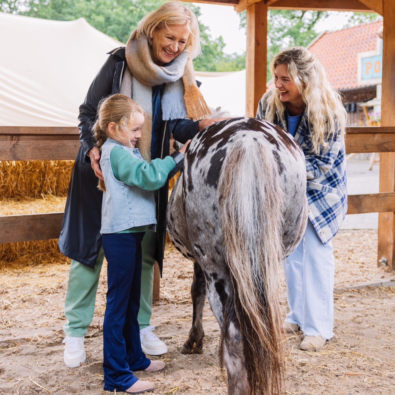 Kind aait een pony bij de ponyranch van Land van Bartje.