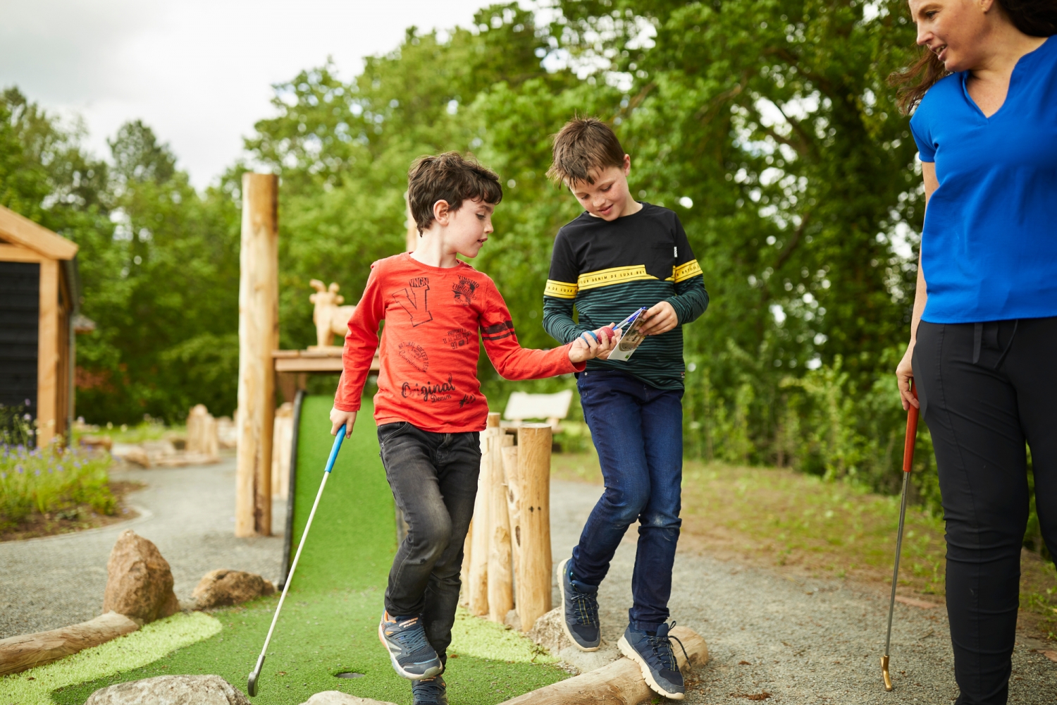 Twee jongens spelen midgetgolf op Het Land van Bartje in Drenthe.