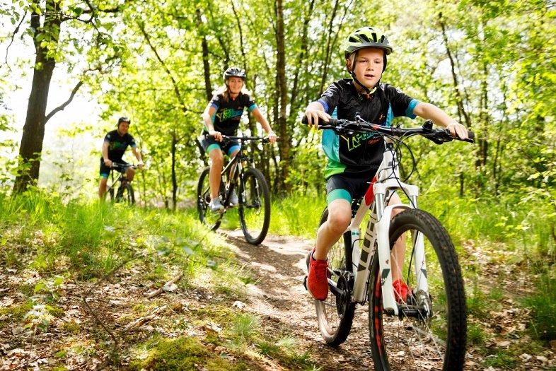 Twee ouderen fietsen op een elektrische fiets bij de fietsverhuur van Land van Bartje.